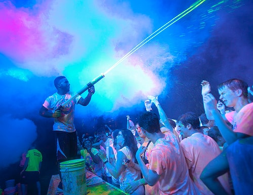 Excited attendee with neon UV paint on their face at a GloZone event