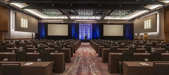 Large conference ballroom with triple projection screens and professional AV setup