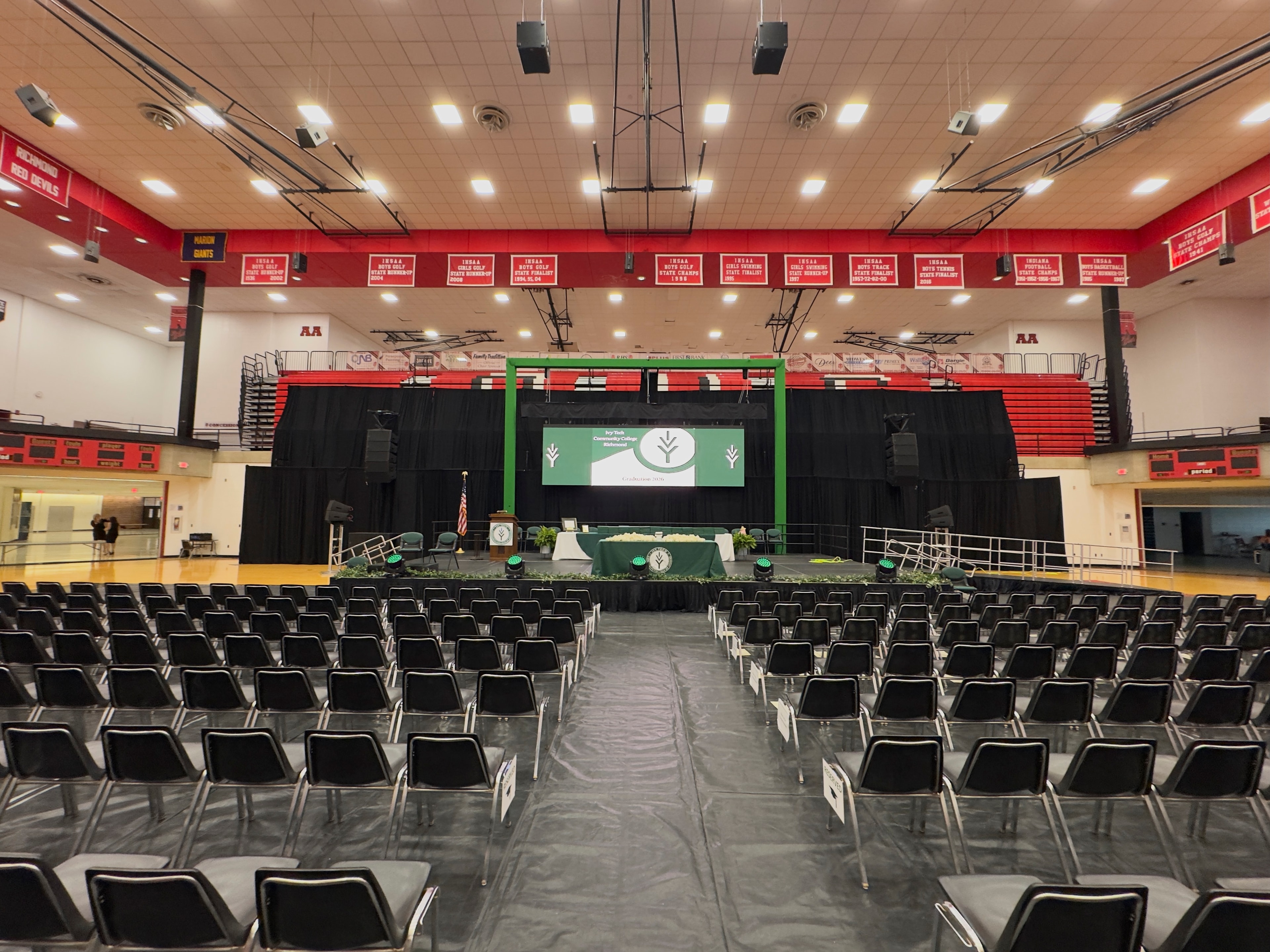 Ivy Tech Community College graduation ceremony stage setup in a school gymnasium