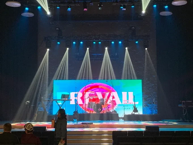 Revail event stage with LED wall and dramatic beam lighting